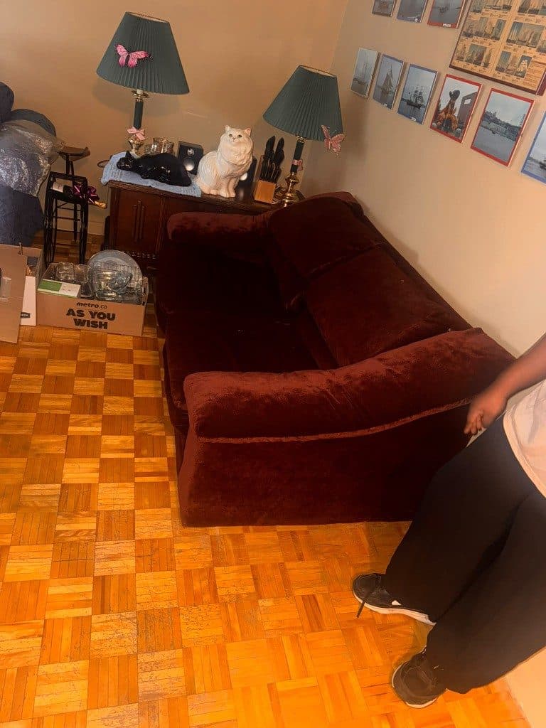 Burgundy sofa and boxes in a room before pickup